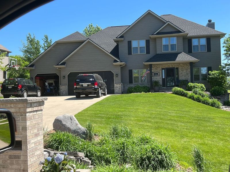 A large house with two cars parked in front of it