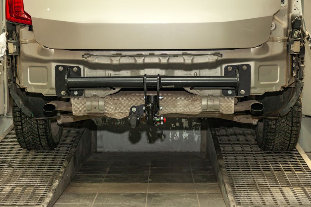 A Car With a Tow Bar Attached to the Back of It is Parked in a Garage — Ace Exhaust Centre in Berserker, QLD