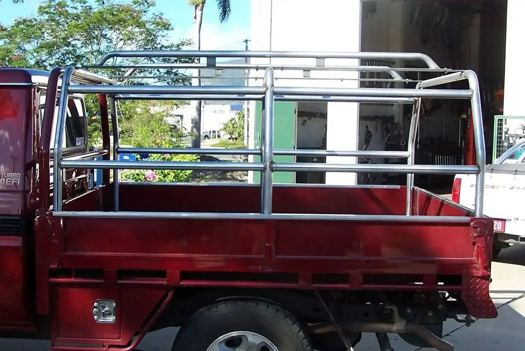 A Red Truck With a Cage on the Back of It — Ace Exhaust Centre in Berserker, QLD