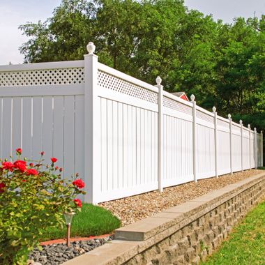 Scarlet and Gray Power Washing - A white fence is surrounded by gravel and flowers
