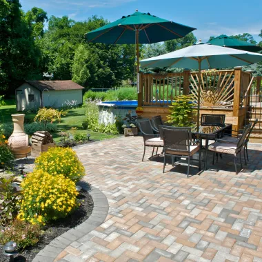 Scarlet and Gray Power Washing - A patio with a table and chairs and umbrellas