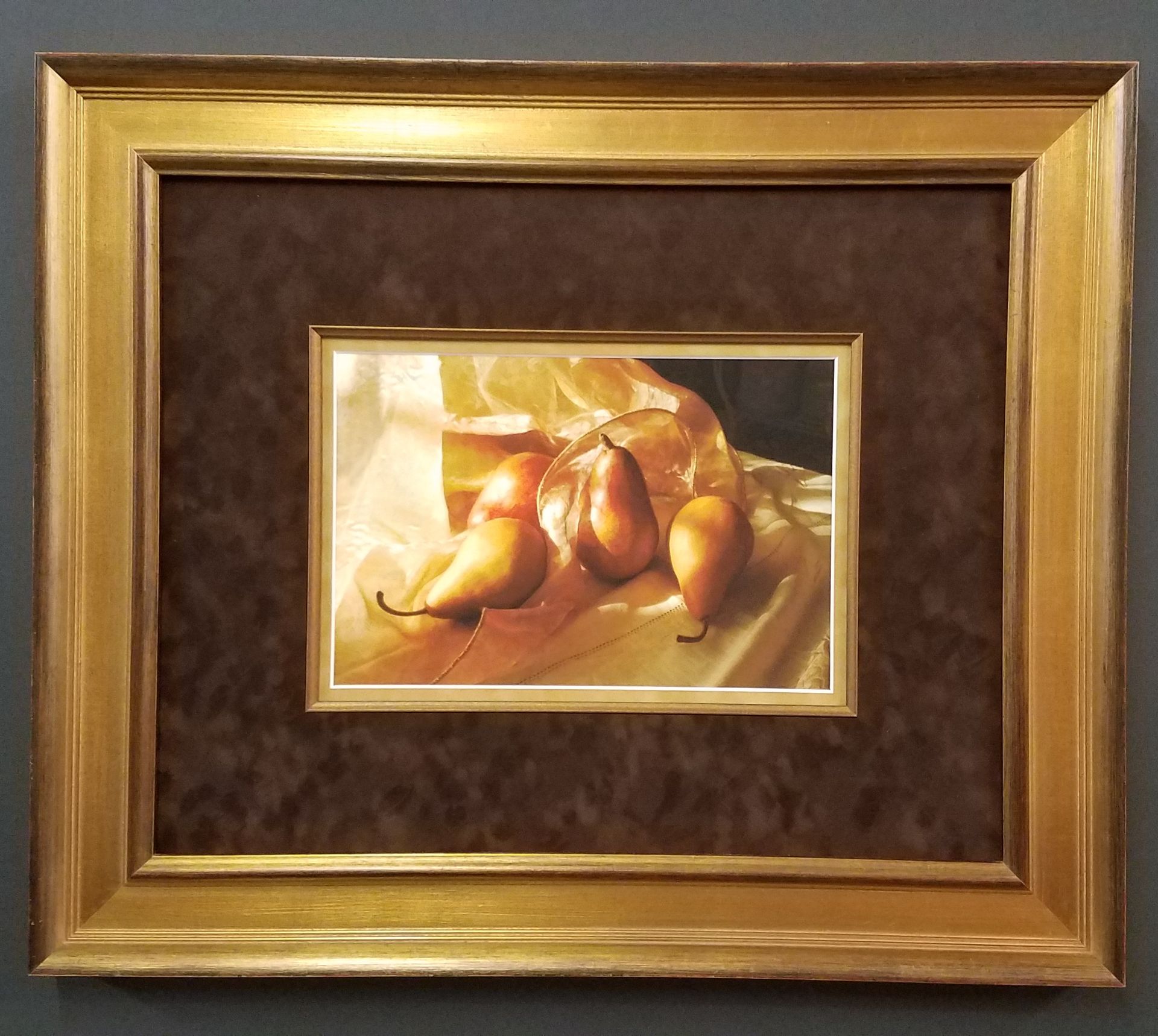 A picture of three pears in a gold frame