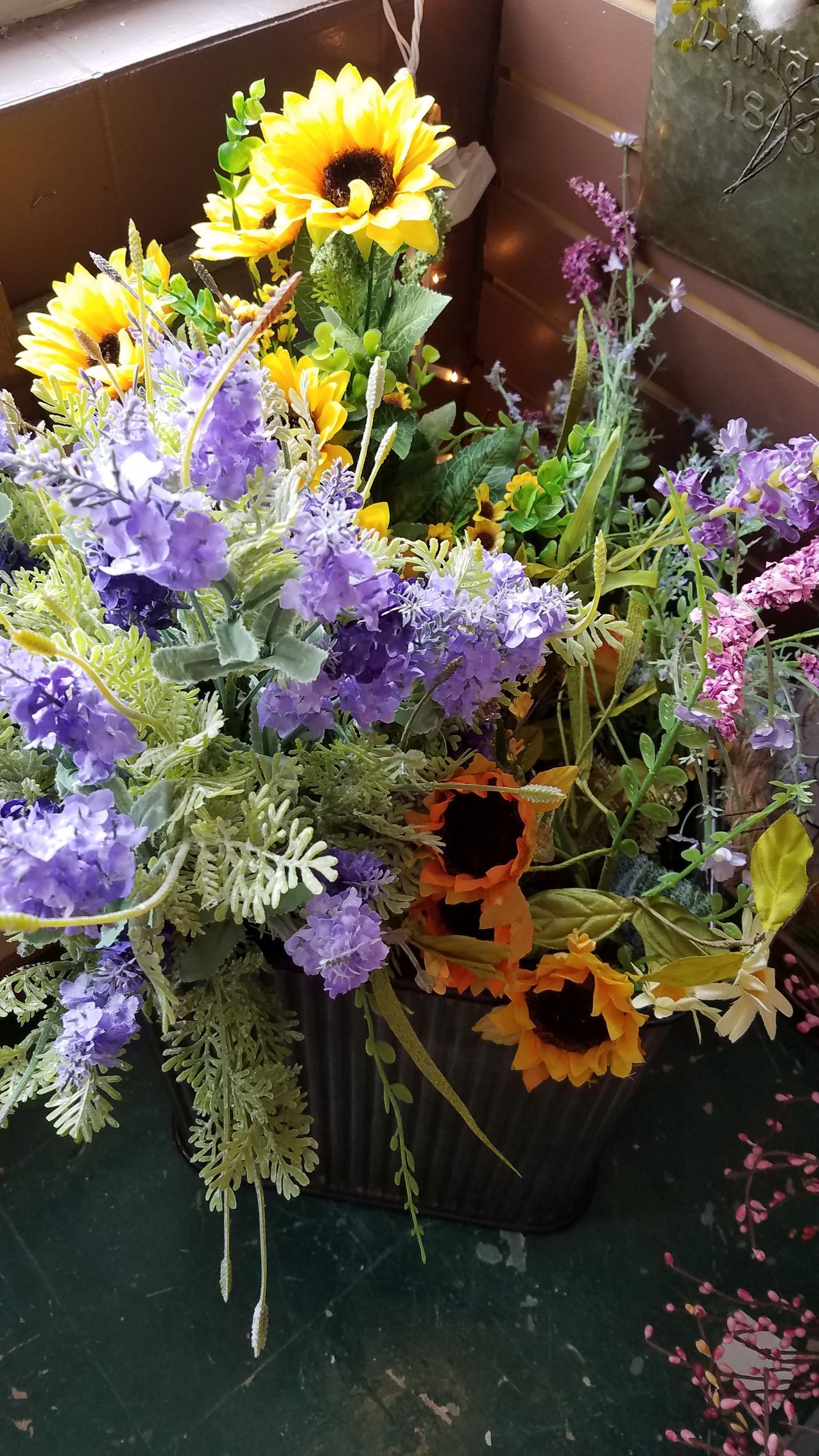 A vase filled with purple and yellow flowers is sitting on a table.