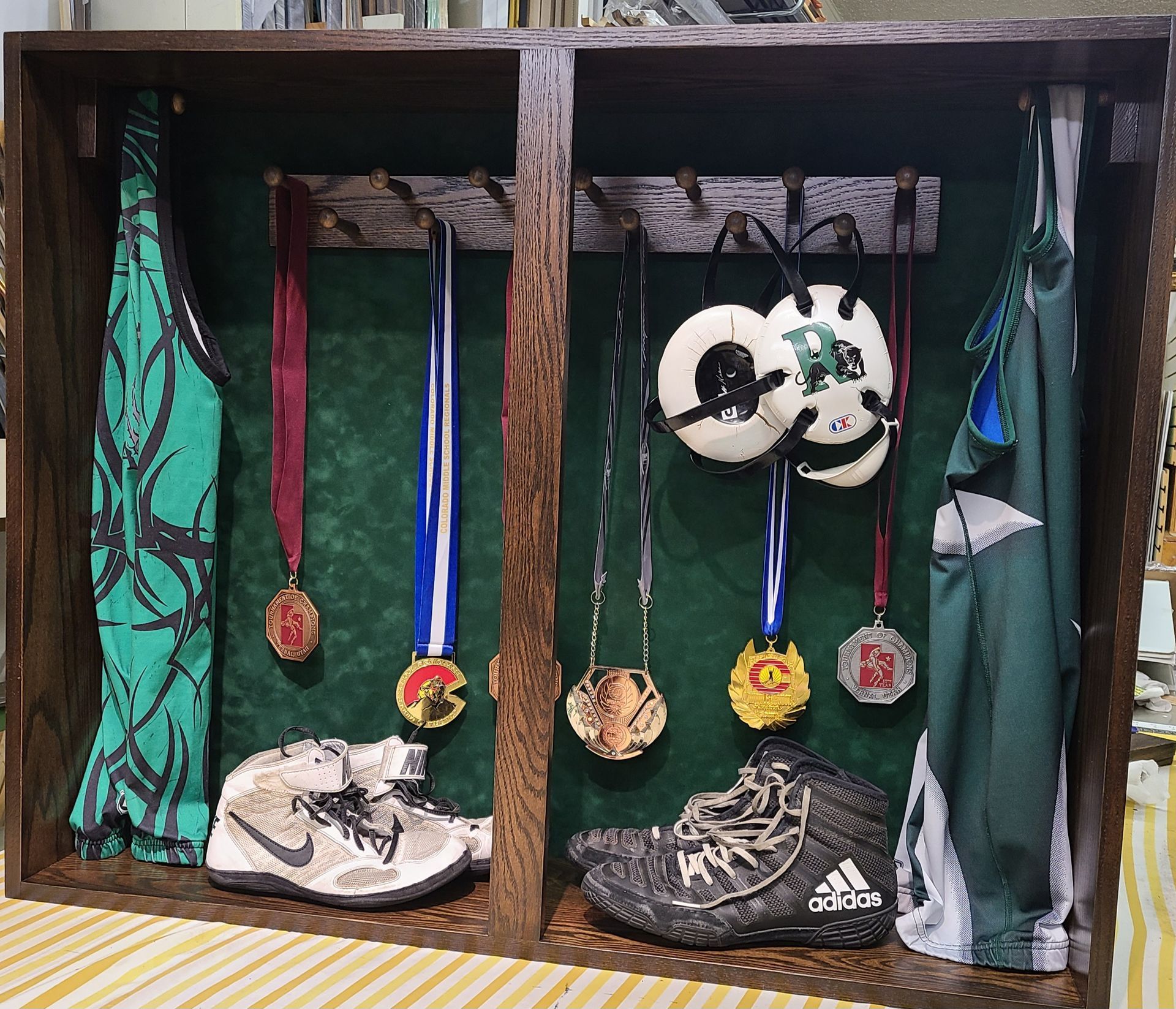A wooden display case with medals hanging from it