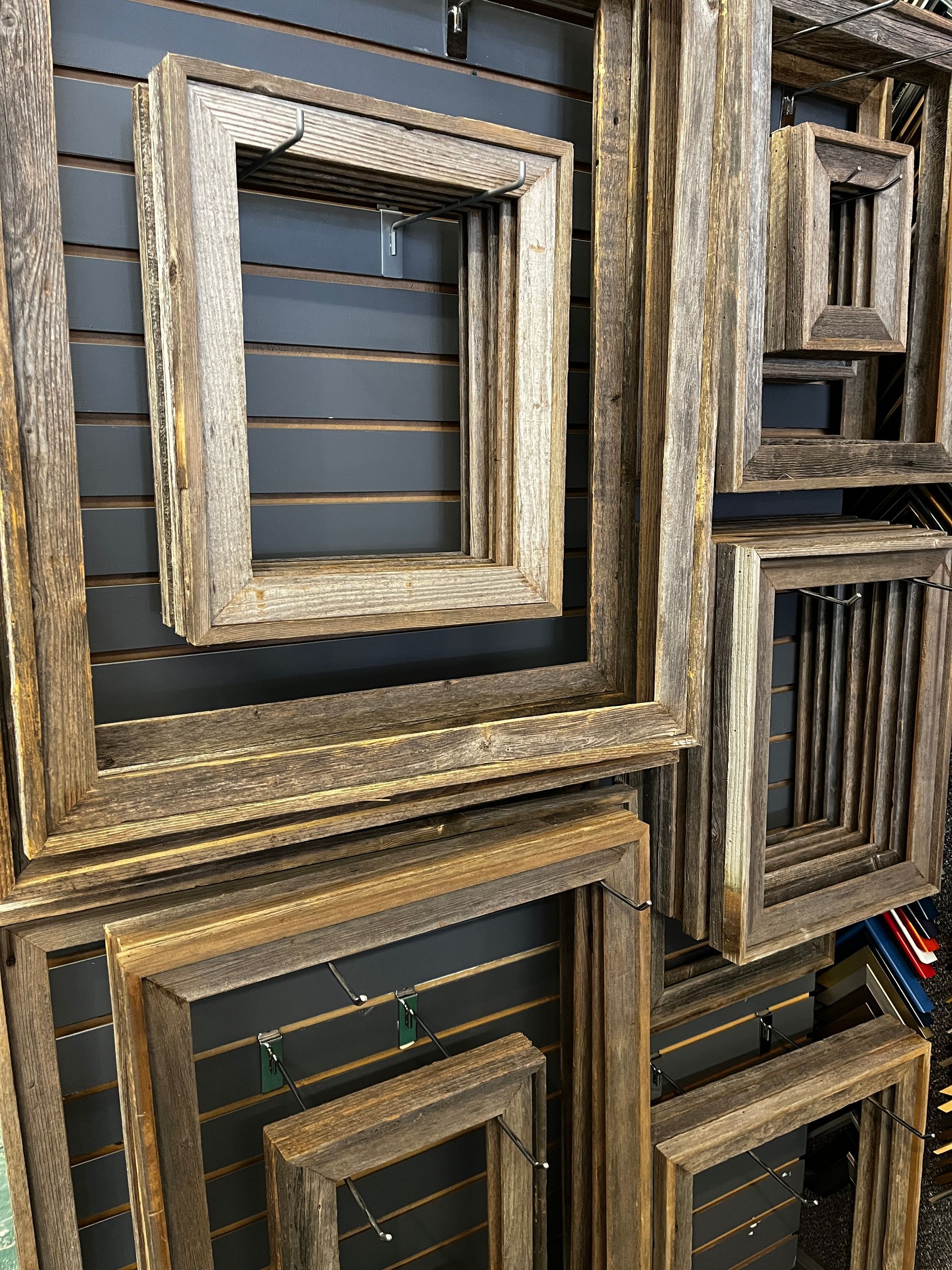 A bunch of wooden frames are stacked on top of each other on a wall.