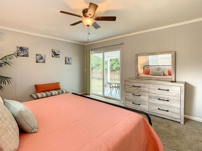Bedroom with ceiling fan and walk-out doors to patio