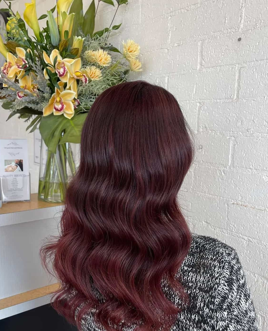 A Person With Wavy, Dark Burgundy Hair is Positioned — Devyani Hair & Beauty in Unanderra, NSW