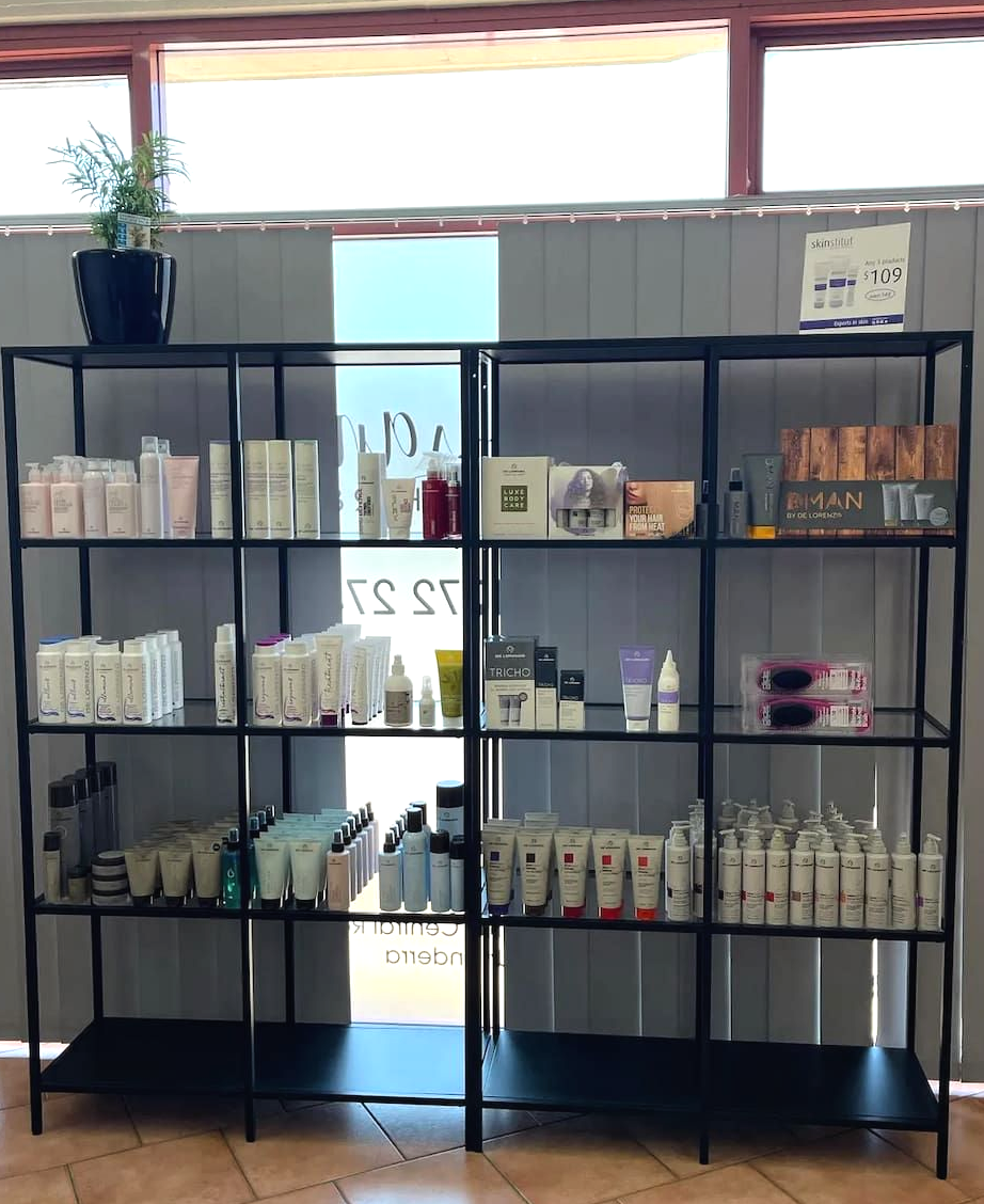 A Black Metal Shelving Unit Filled With Various Skincare and Beauty Product Bottles — Devyani Hair & Beauty in Unanderra, NSW
