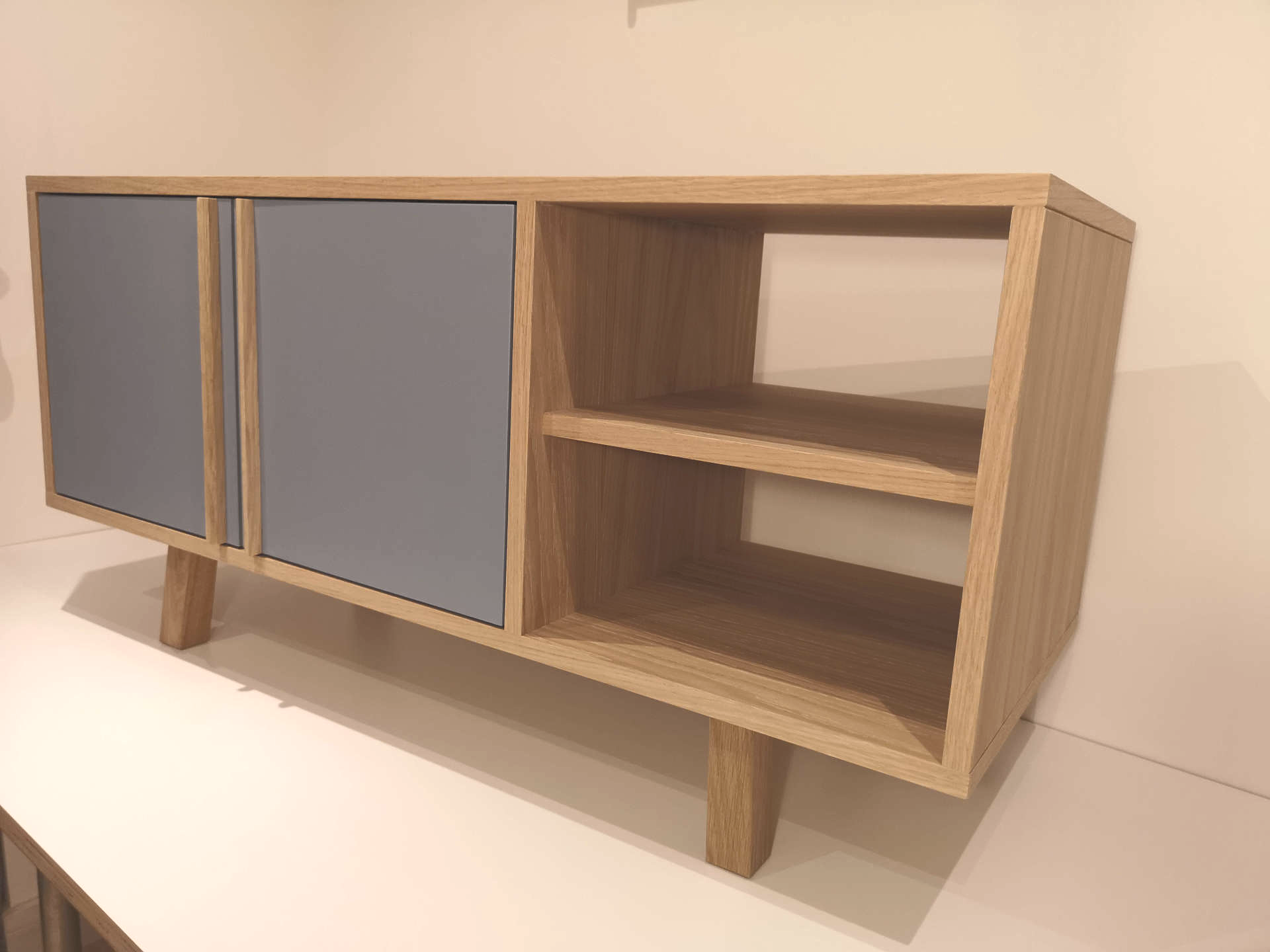 Bespoke oak veneer sideboard with blue painted doors and open shelves.