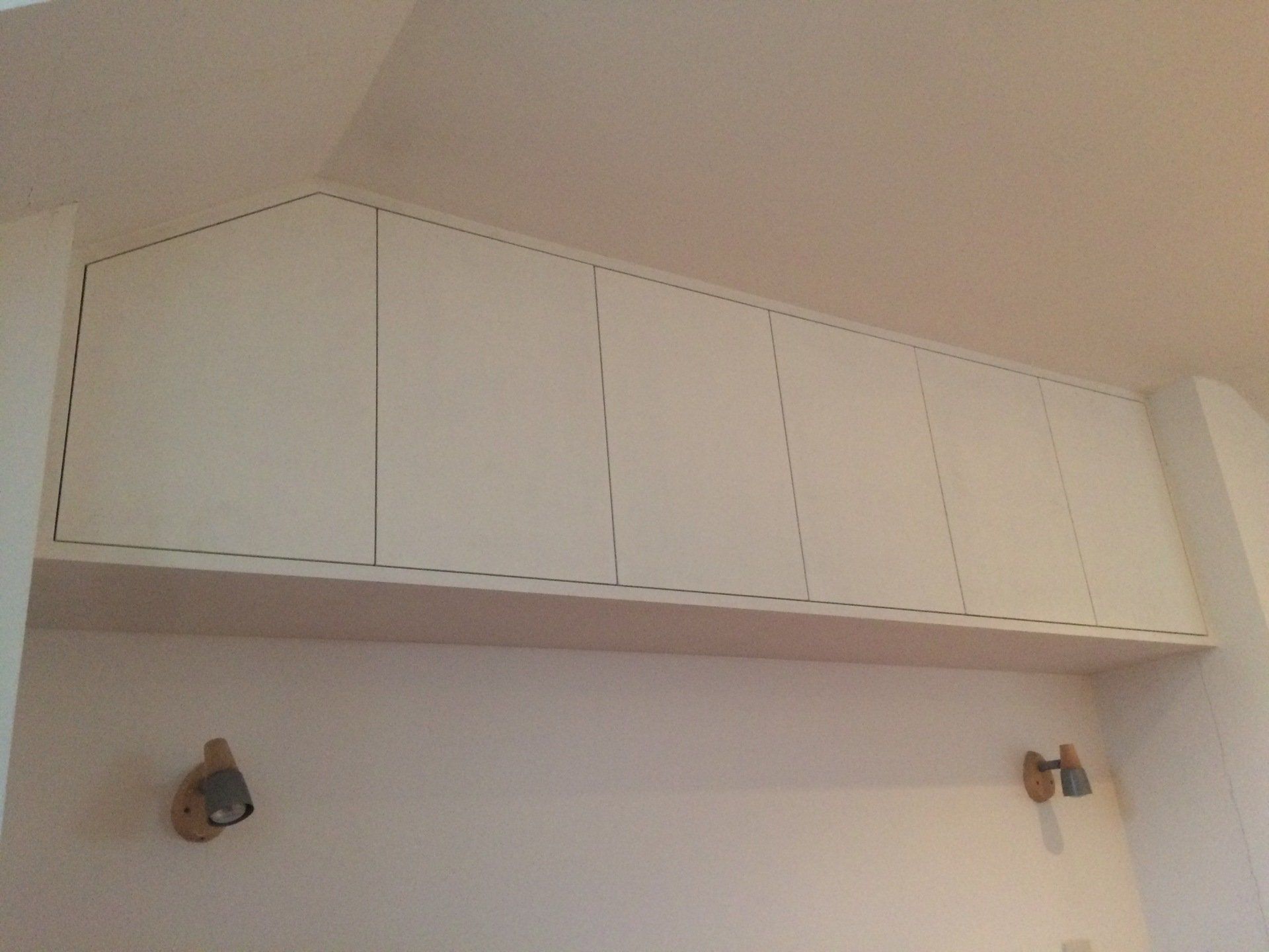 Above bed cupboards with push to open slab doors.