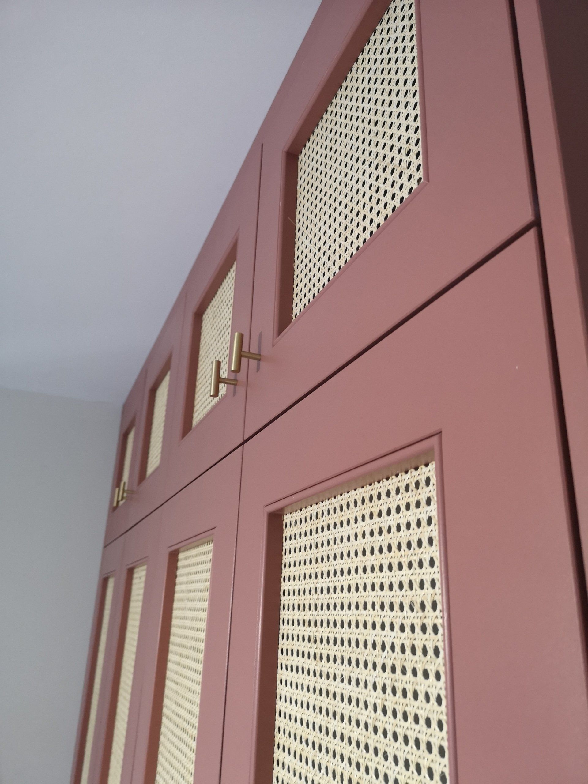 Pink fitted wardrobe with rattan style shaker doors and gold t bar handles