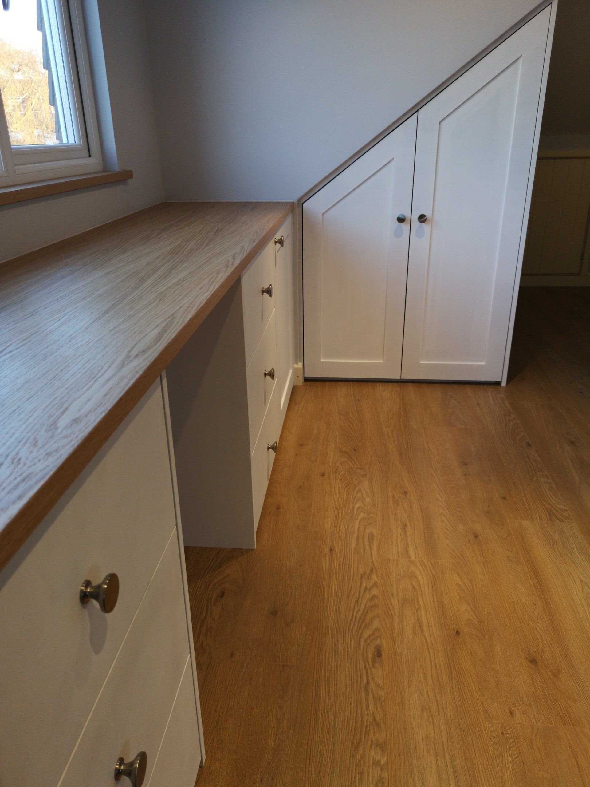 Fitted bedroom with dressing table, white soft close drawers shaker cupboard doors and oak veneer top.