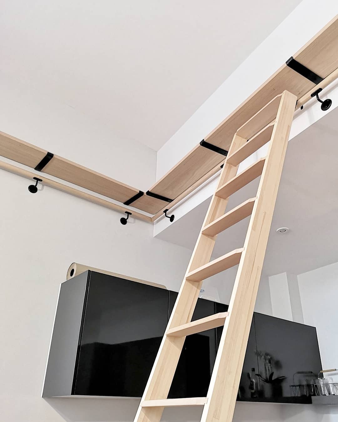 Oak bookshelf on raw steel brackets with sliding library ladder