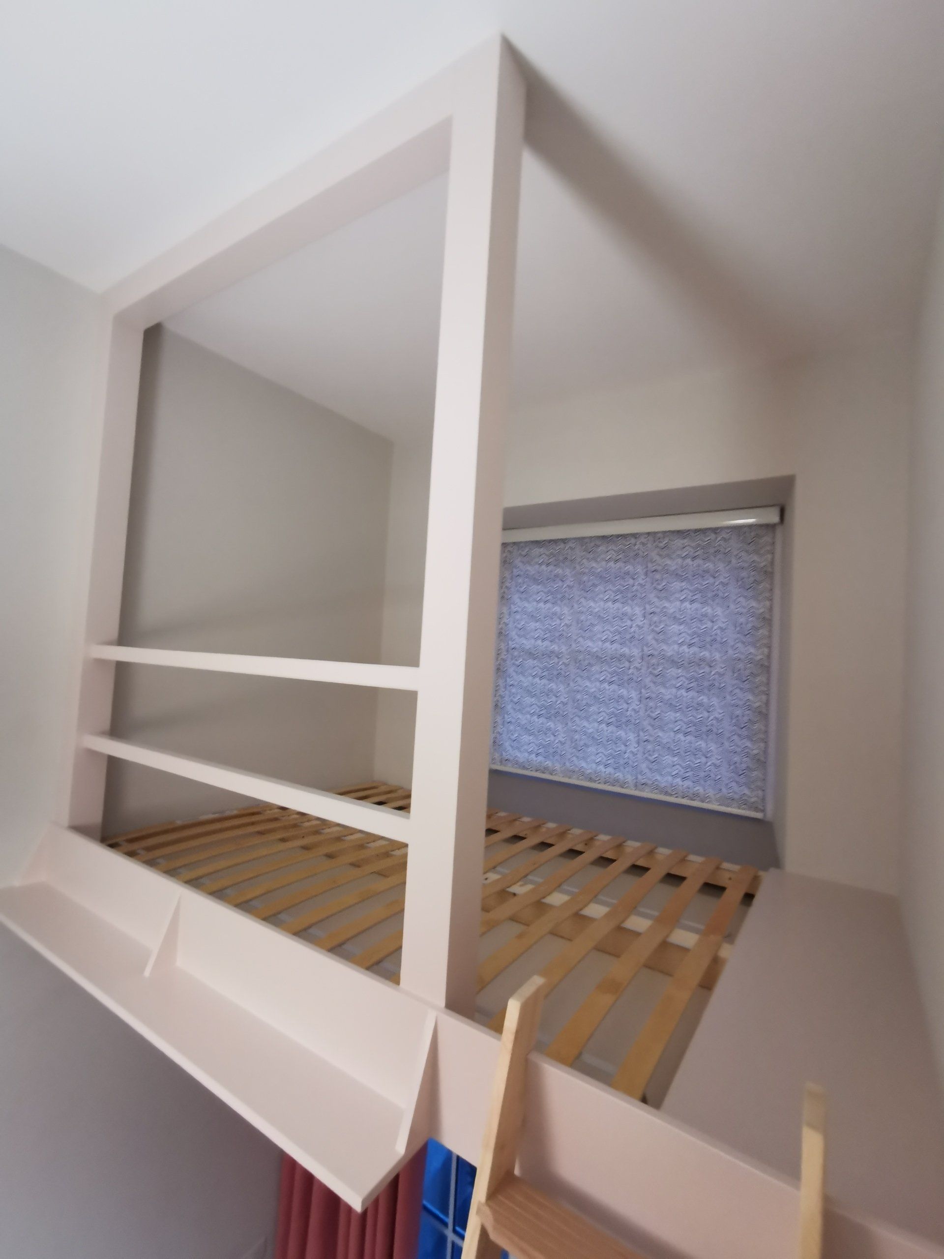 A mezzanine style loft bed fitted with a ladder, safety rails and fully painted in a light pink.