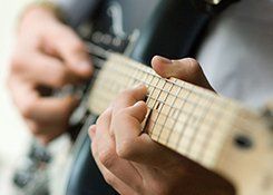 Close view of a hand around the neck of a guitar