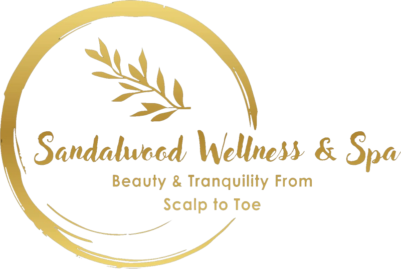 Logo for Sandalwood Wellness & Spa, featuring a gold circular design with text and a sprig of leaves. The tagline reads 