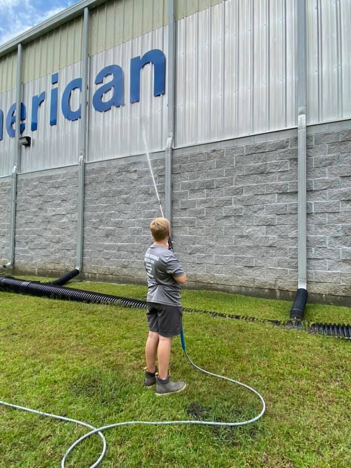 Cleaning The Warehouse Exterior Using Pressure Washer