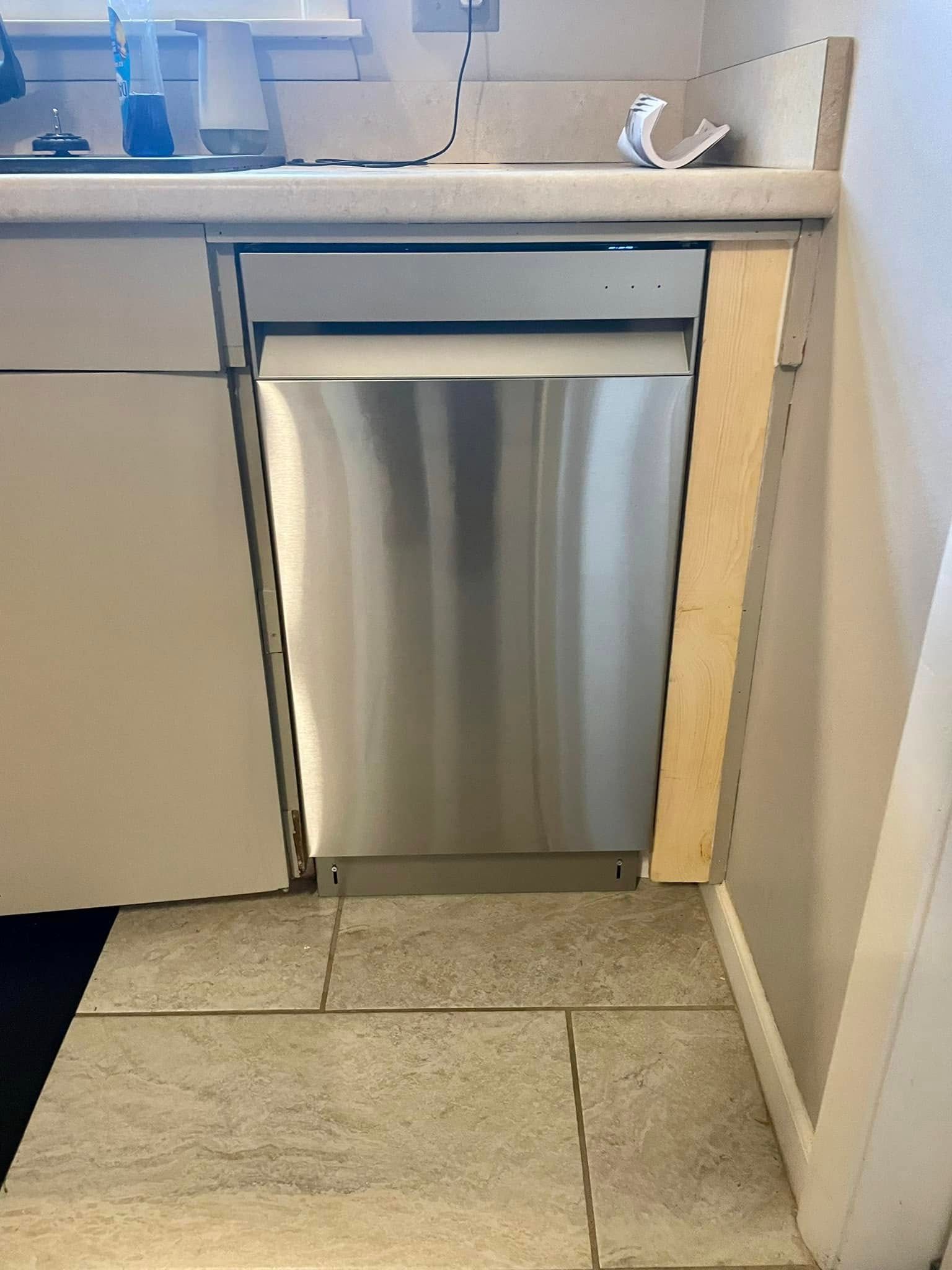 A stainless steel dishwasher is sitting under a counter in a kitchen.