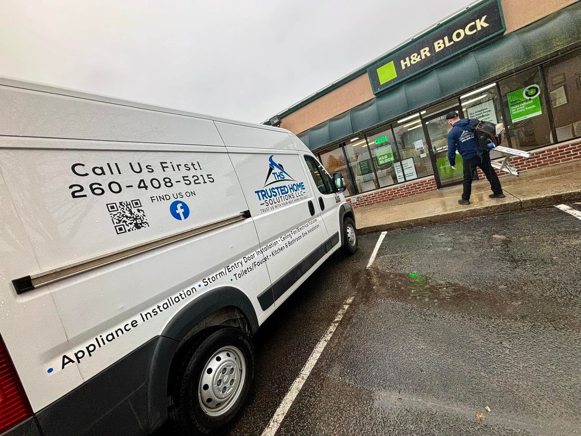 A white van is parked in front of a store.