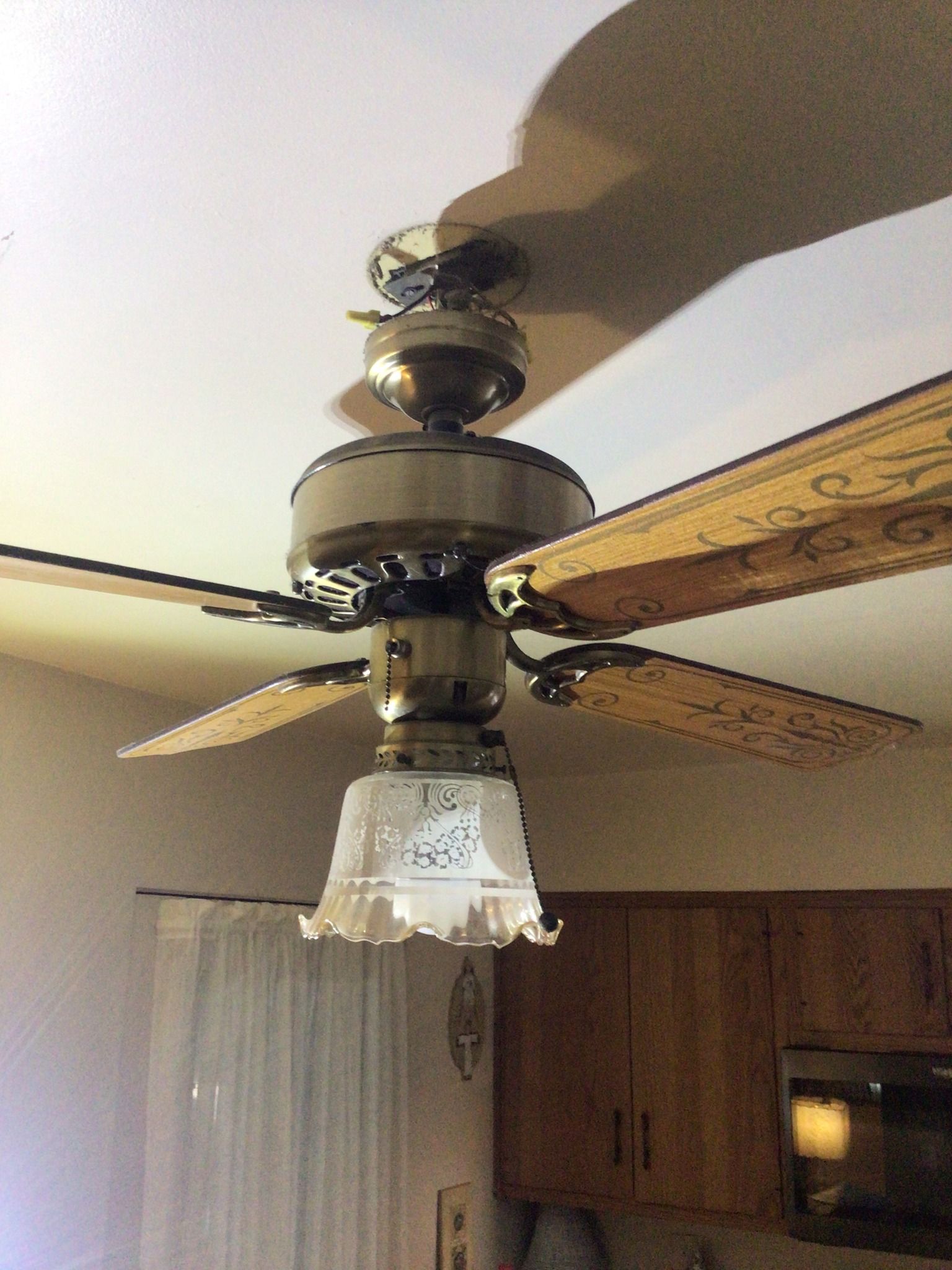 A ceiling fan is hanging from the ceiling in a kitchen