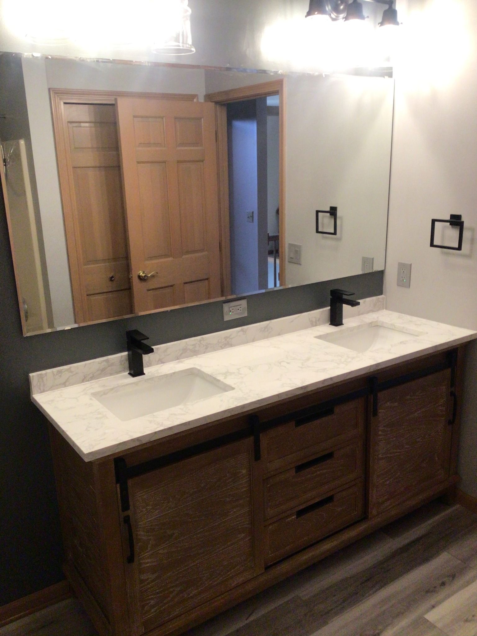 A bathroom with two sinks and a large mirror.