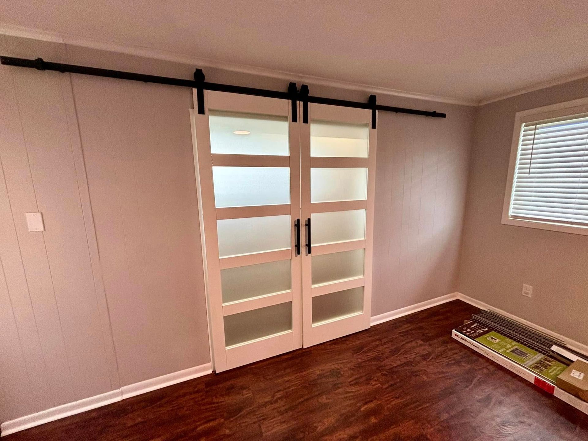 A room with sliding barn doors and a window.