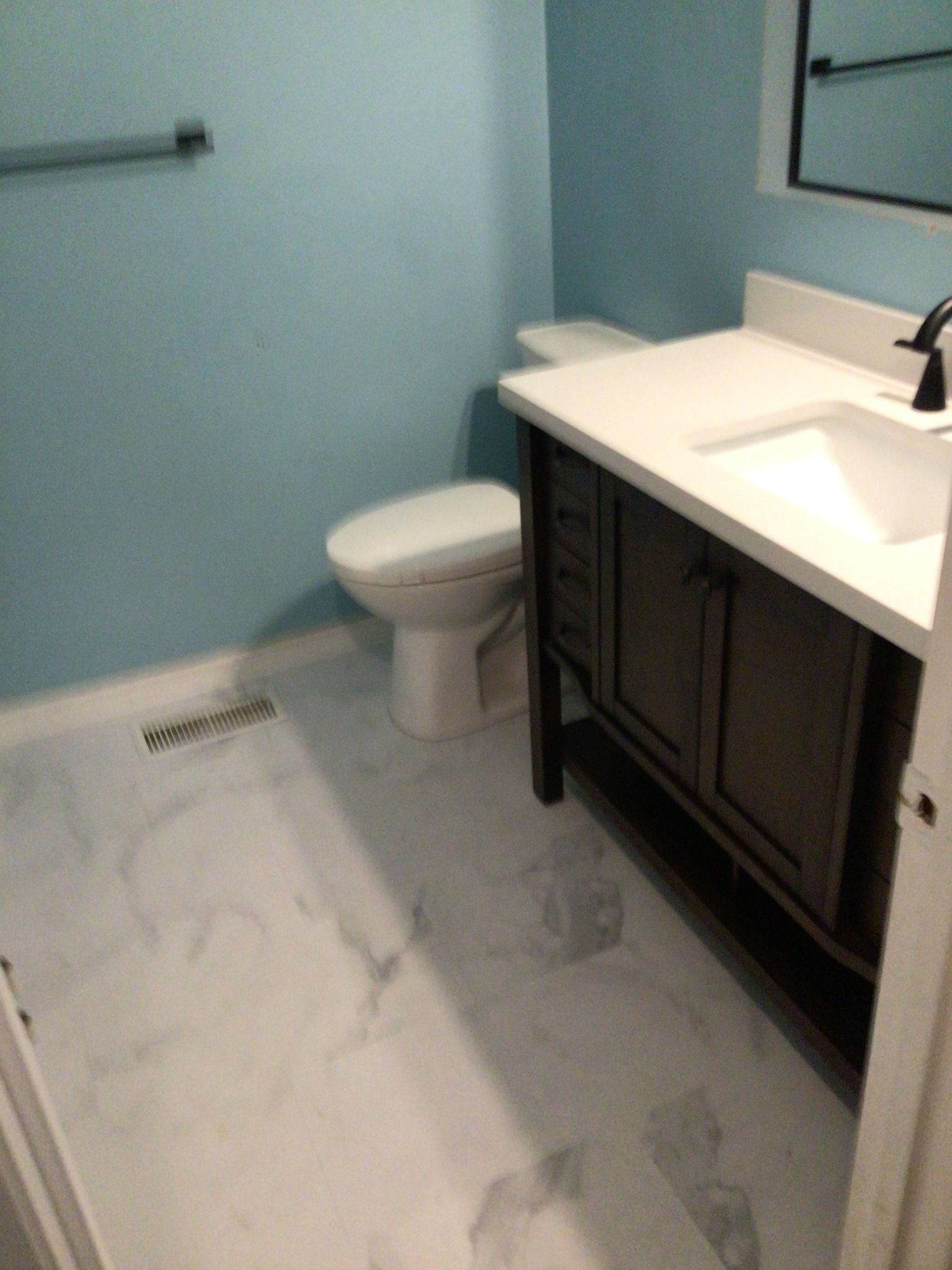A bathroom with a toilet , sink and mirror