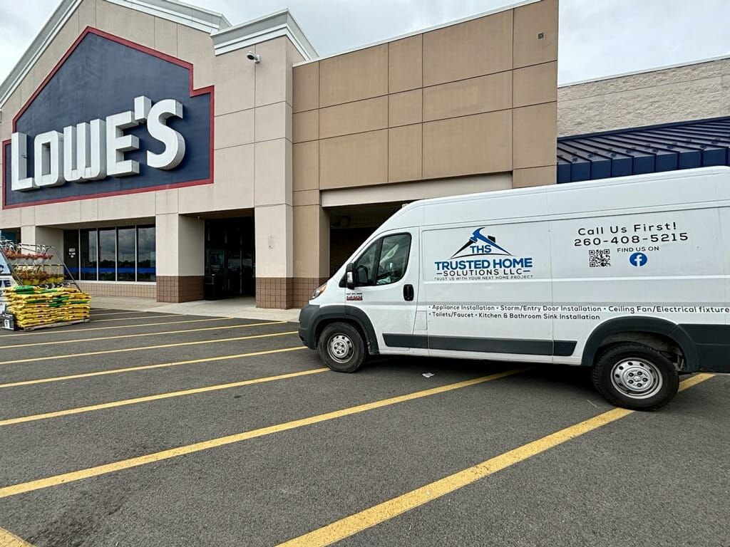 A white van is parked in front of a lowe 's store.