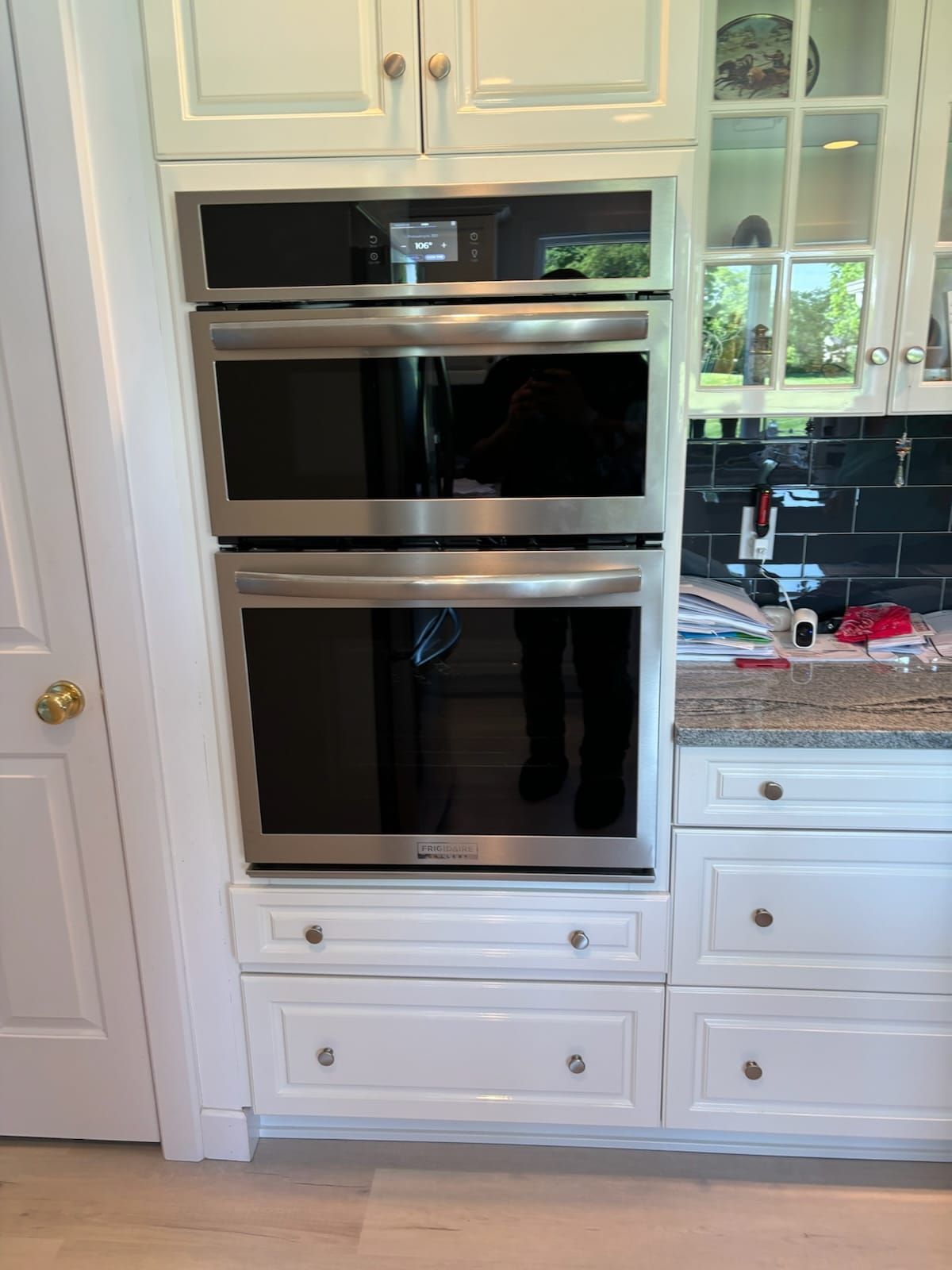 A kitchen with white cabinets and stainless steel ovens.