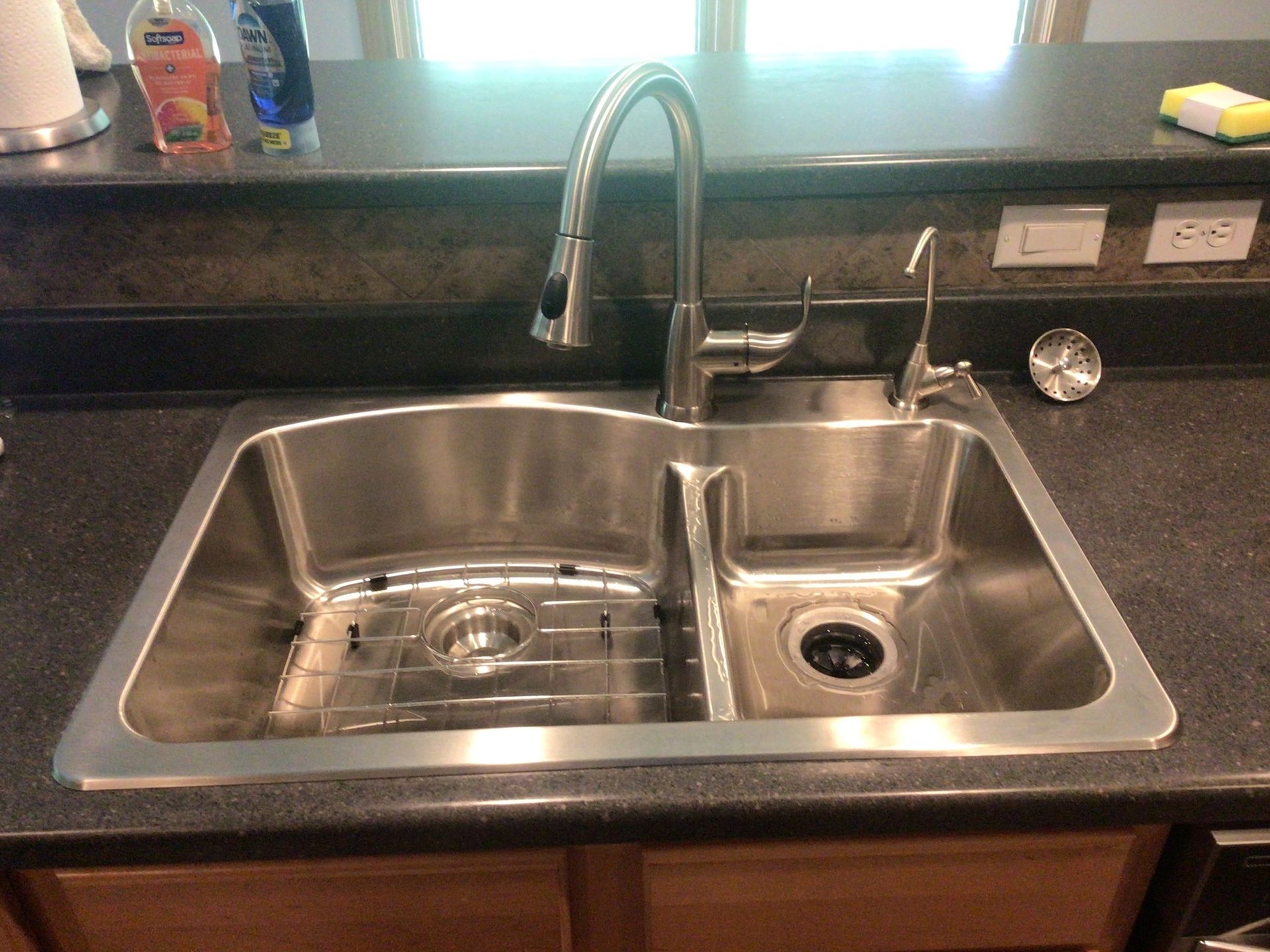 A stainless steel kitchen sink with a faucet
