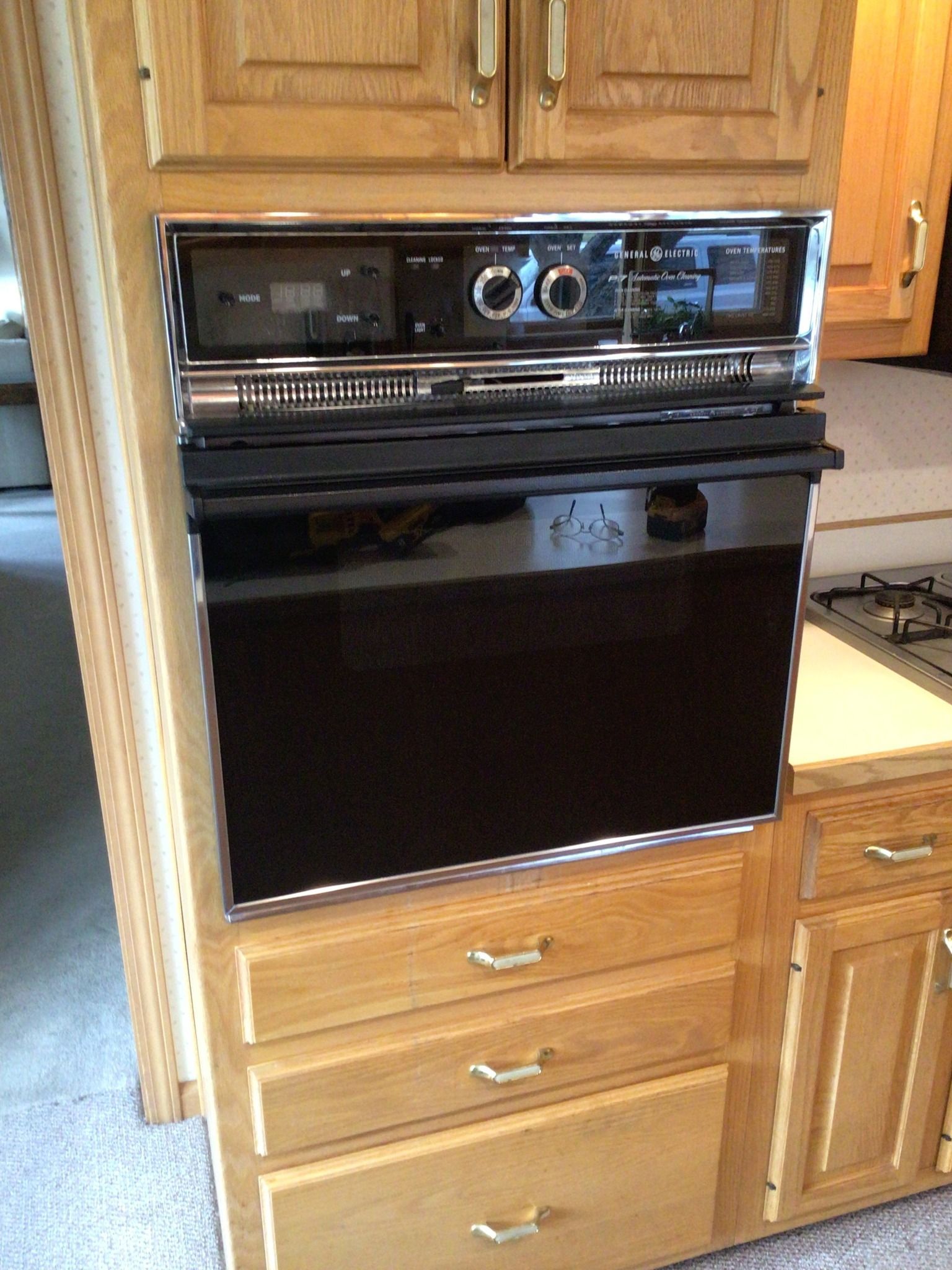 A black oven is sitting on top of a wooden cabinet
