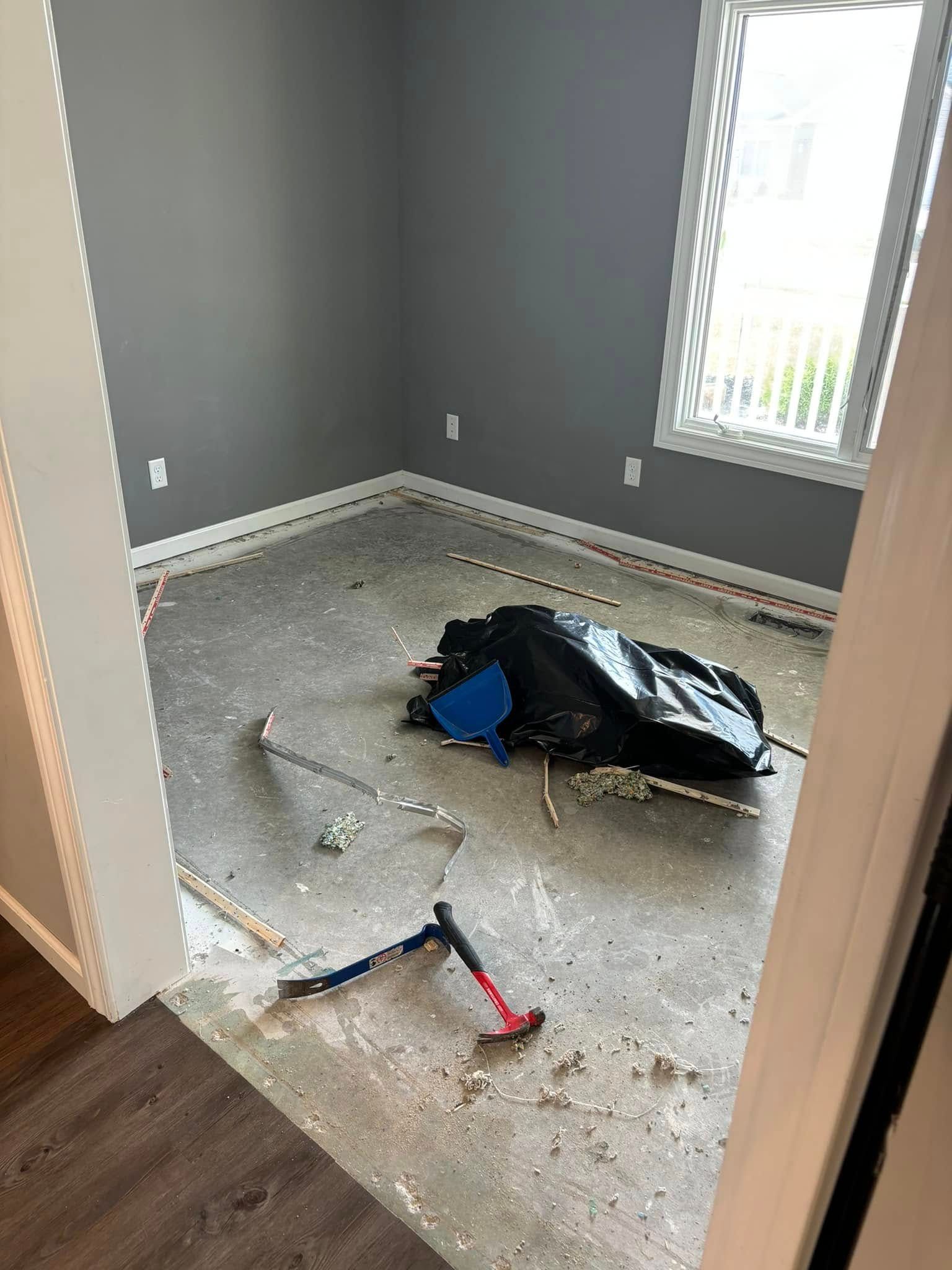 A room with a hammer and a bag on the floor.