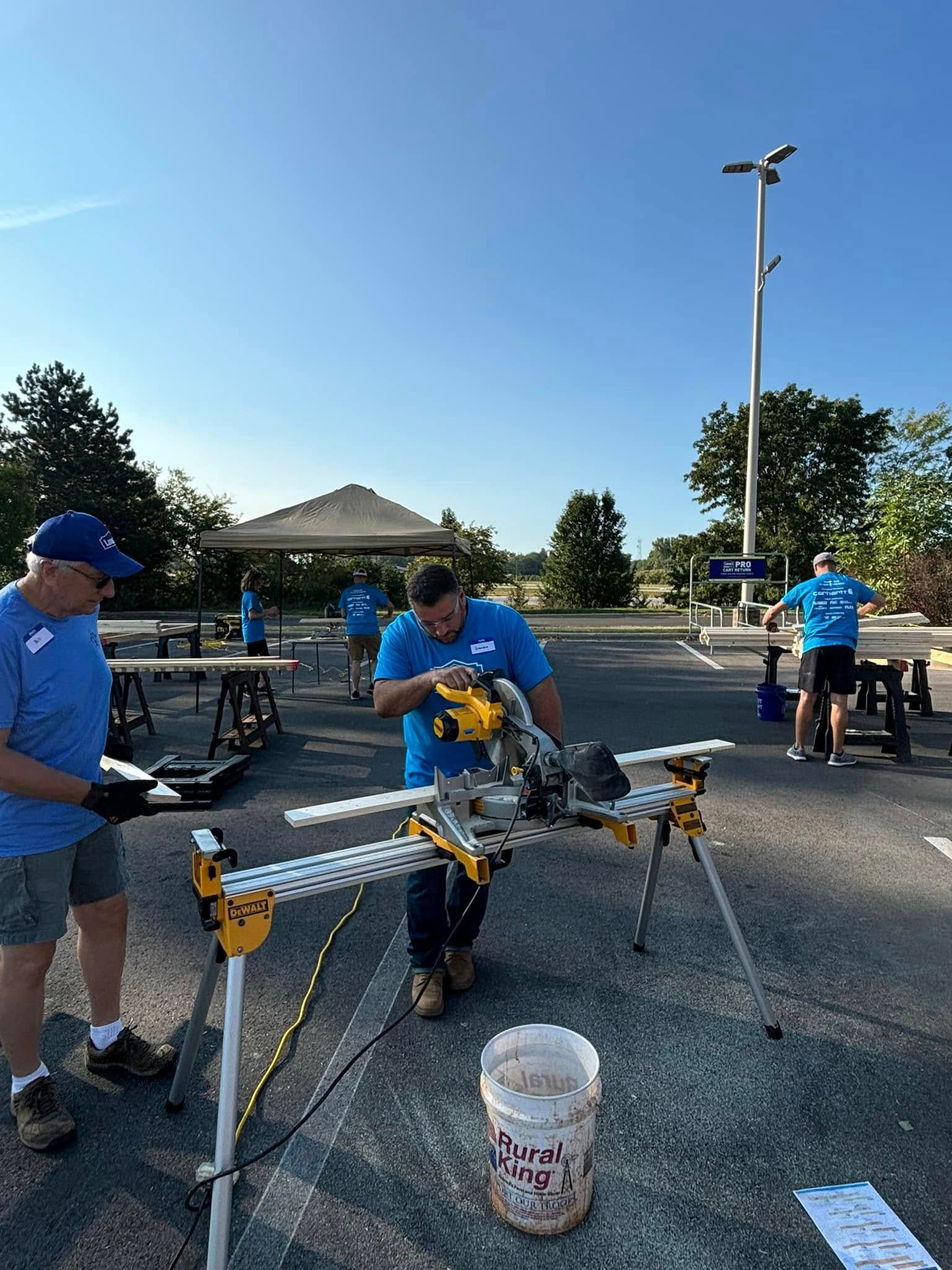 A group of men are working on a project in a parking lot.