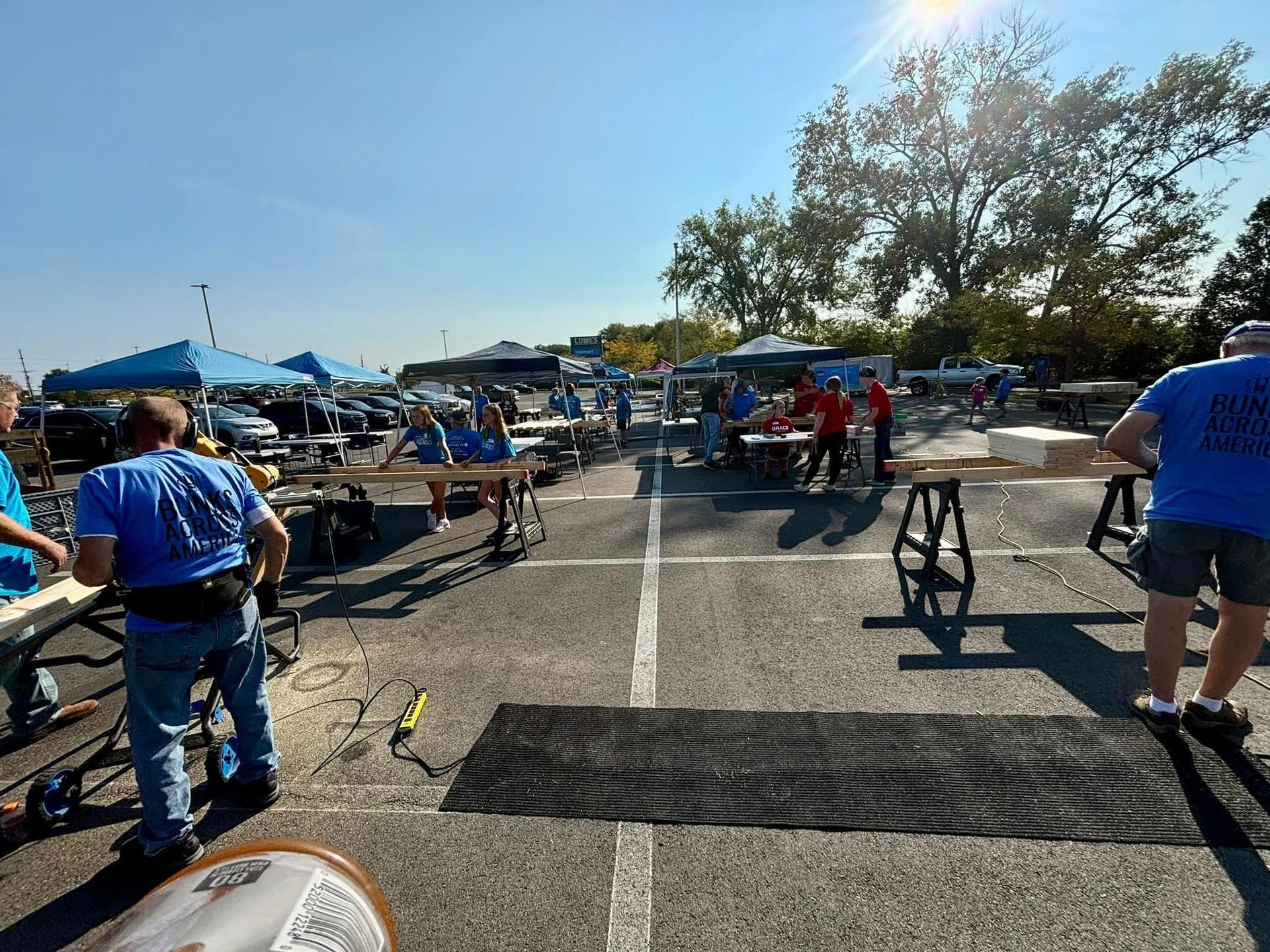 A group of people in blue shirts are standing in a parking lot