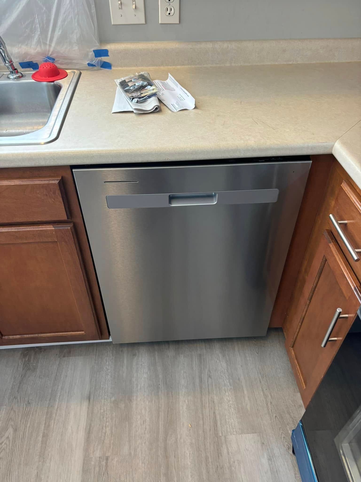 A kitchen with a stainless steel dishwasher and a sink.
