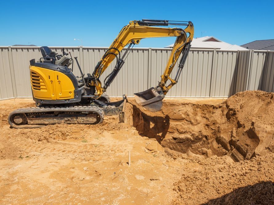 A Bulldozer And An Excavator Are Working On A Construction Site — Tuscany Concreting In Bowen, QLD
