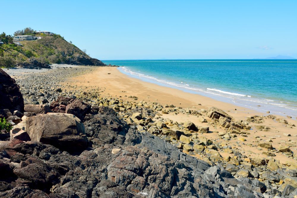 Beach With A Large Rock In The Foreground — Tuscany Concreting In Whitsundays, QLD