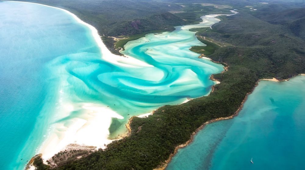 An Aerial View Of A Large Body Of Water With A River Running Through It — Tuscany Concreting In Whitsundays, QLD