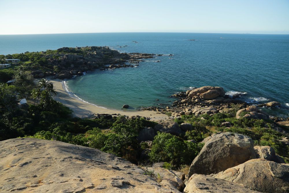 A View Of A Beach From A Rocky Cliff Overlooking The Ocean — Tuscany Concreting In Bowen, QLD