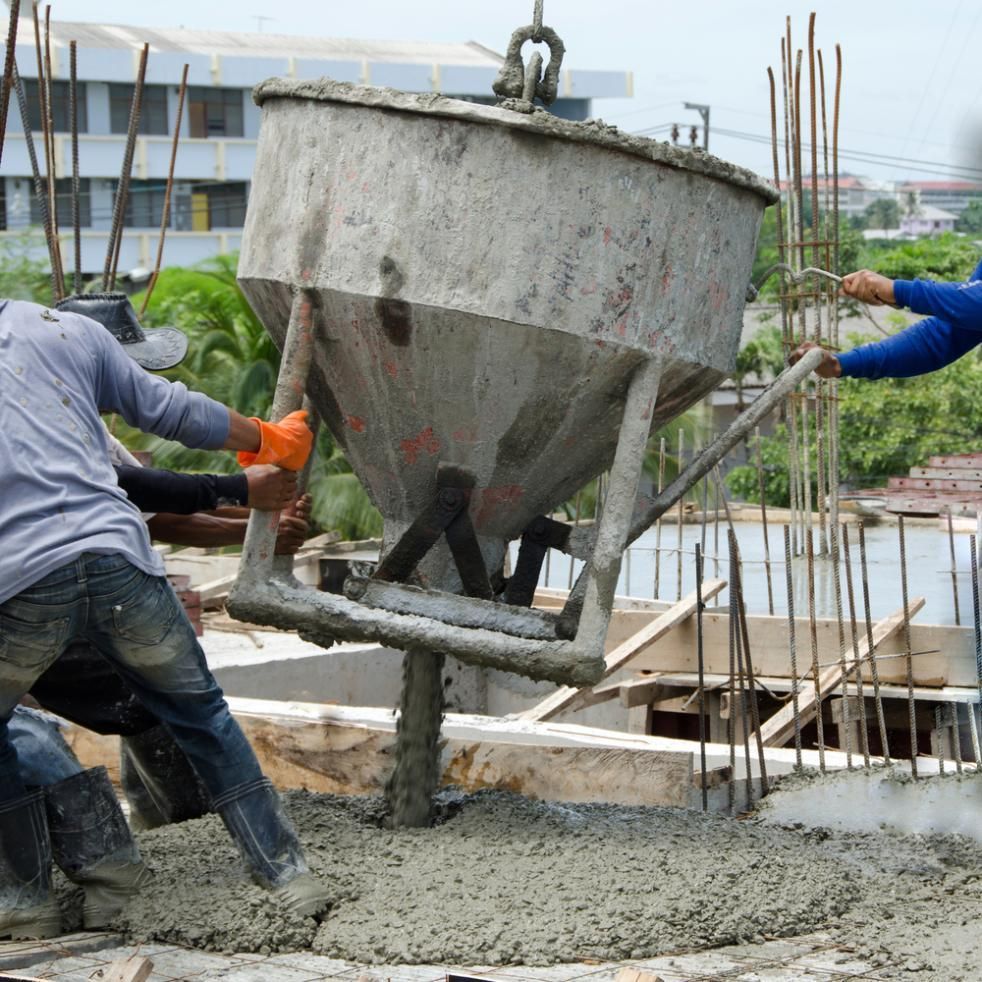 A Group Of Construction Workers Are Pouring Concrete Into The Ground — Tuscany Concreting In Proserpine, QLD