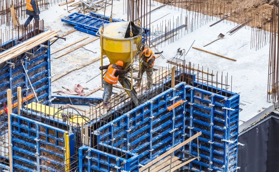 A Group Of Construction Workers Are Working On A Building Under Construction — Tuscany Concreting In Cannonvale, QLD