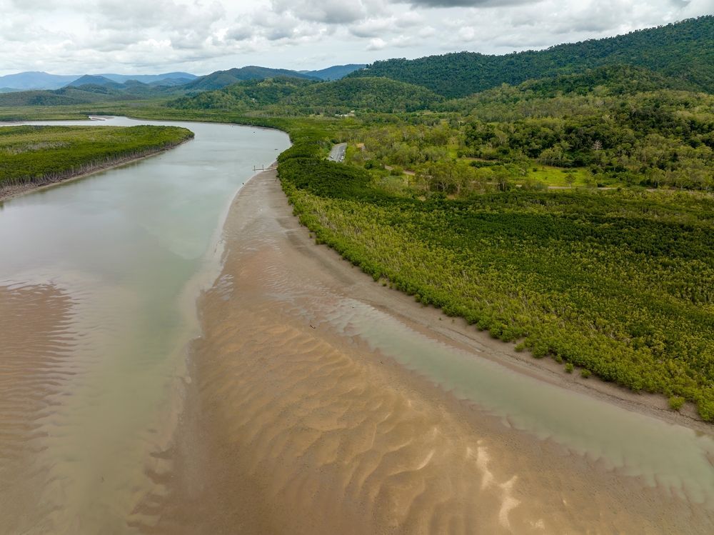An Aerial View Of A River Surrounded By Trees And Mountains — Tuscany Concreting In Proserpine, QLD