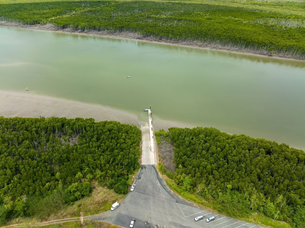 An Aerial View Of A Road Leading To A Body Of Water Surrounded By Trees — Tuscany Concreting In Proserpine, QLD