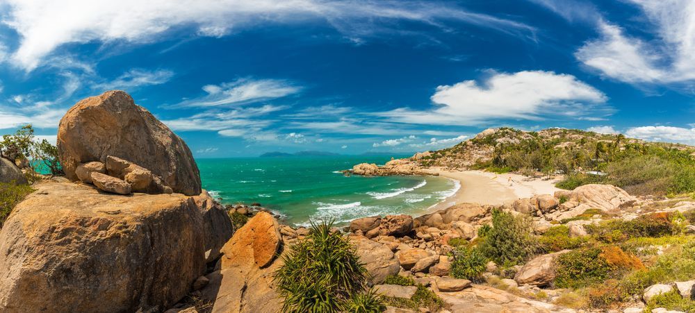 A Panoramic View Of A Beach With A Large Rock In The Foreground — Tuscany Concreting In Bowen, QLD