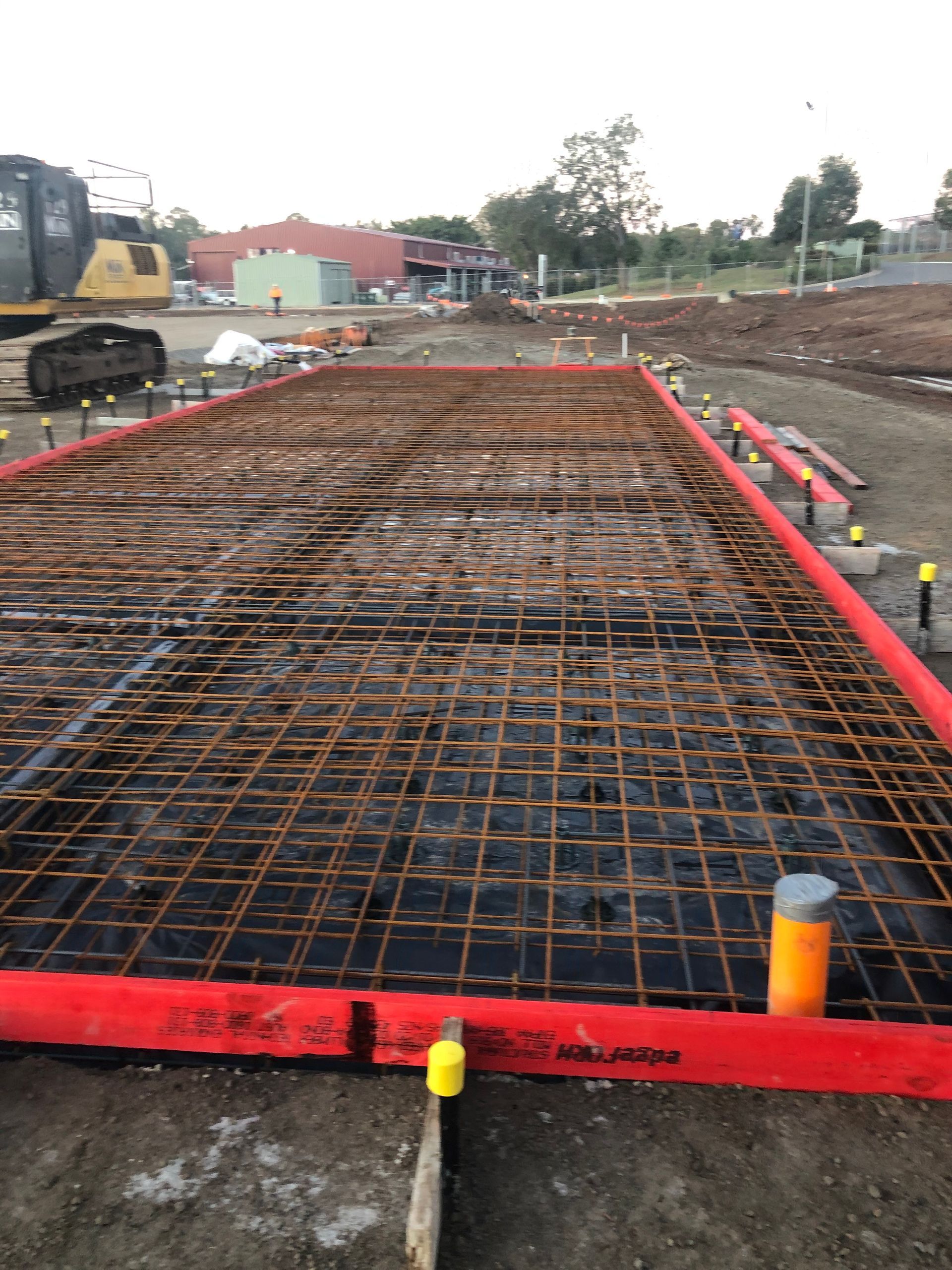 A Man Is Pouring Concrete Into A Pool — Tuscany Concreting In Airlie Beach, QLD