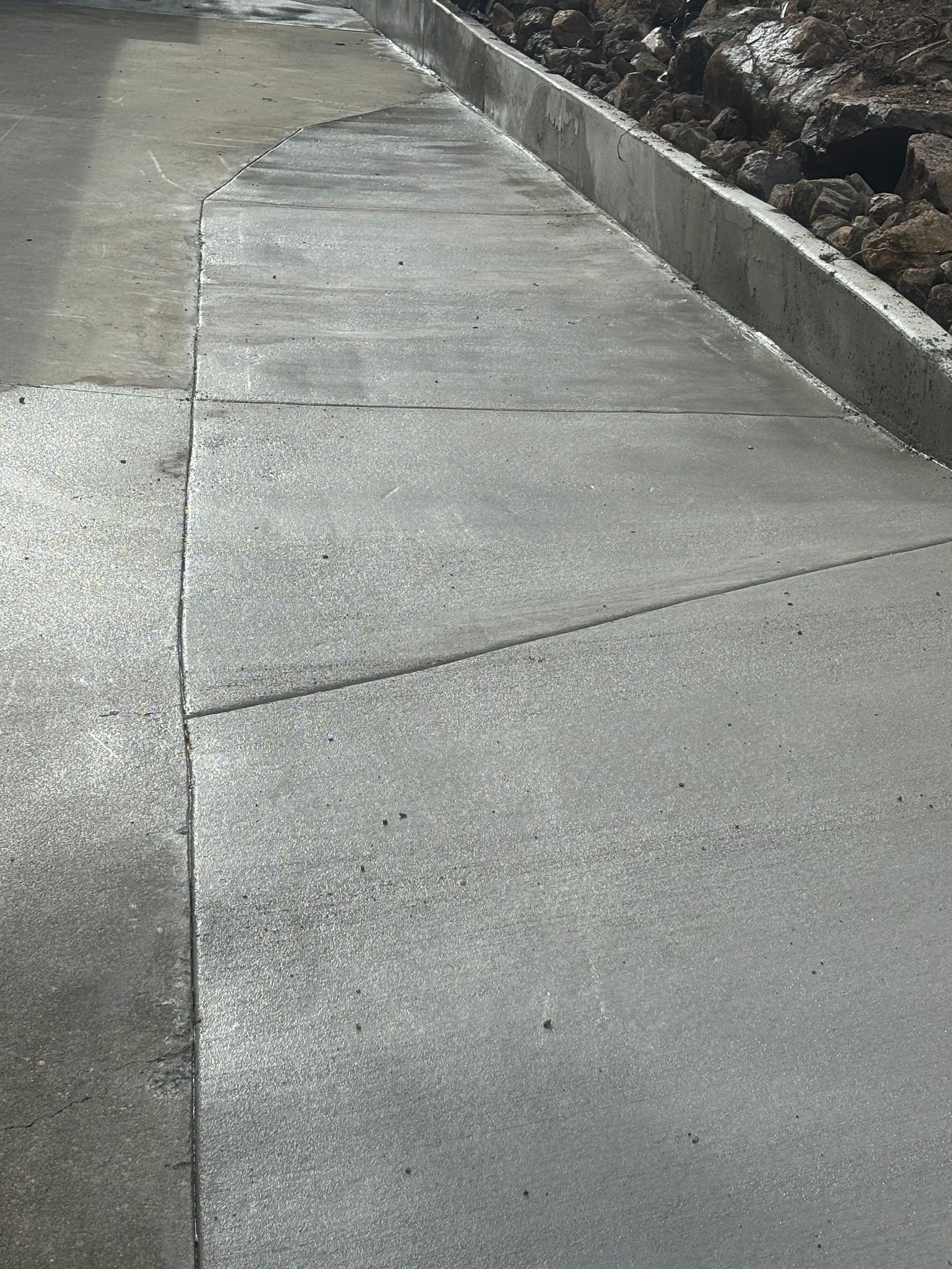 A Construction Worker Wearing A Green Hard Hat Is Working On A Wall — Tuscany Concreting In Whitsundays, QLD