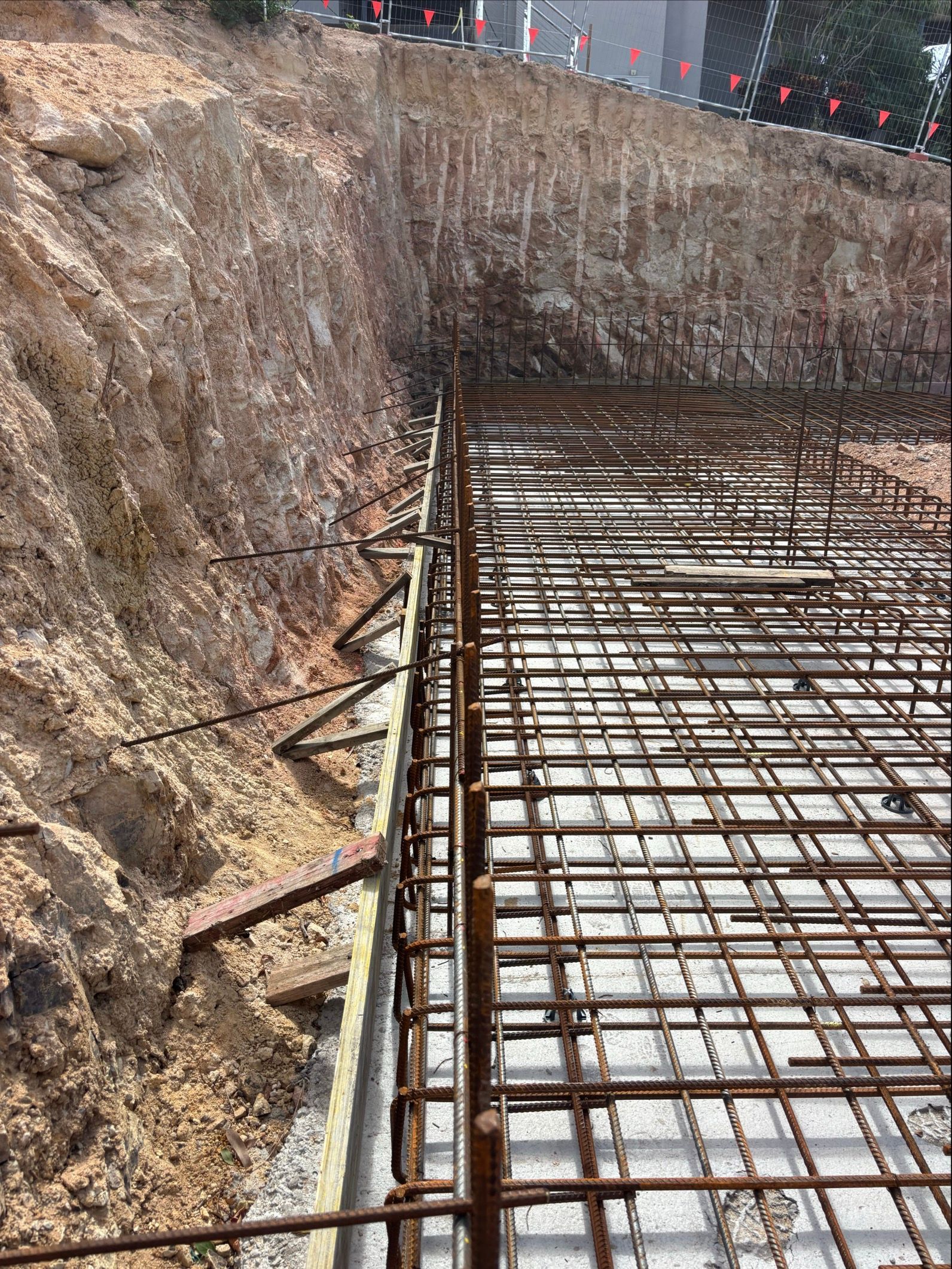 A Man Is Pouring Concrete Into A Pool — Tuscany Concreting In Airlie Beach, QLD