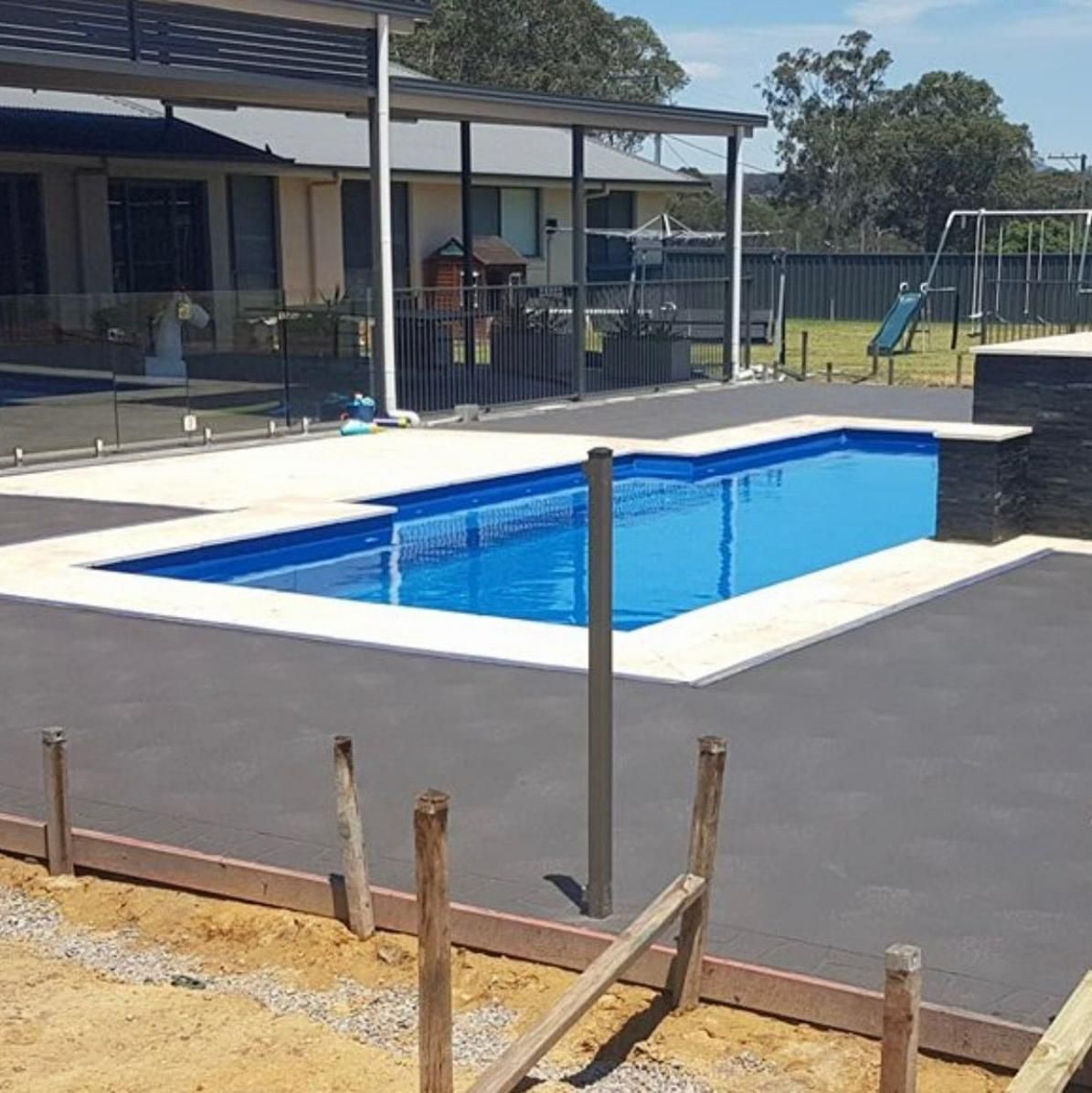 Large Swimming Pool In The Backyard Of A House With Concrete Pool Deck — Tuscany Concreting In Whitsundays, QLD
