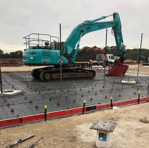 A Blue Excavator With The Word Min On It — Tuscany Concreting In Bowen, QLD
