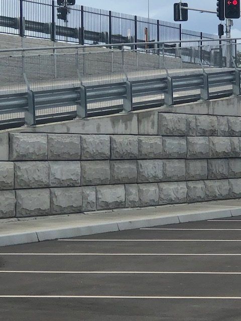 A Parking Lot With A Concrete Wall And A Fence — Tuscany Concreting In Bowen, QLD